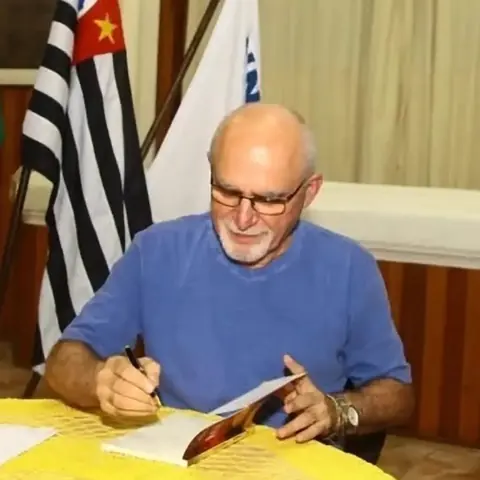 Benedito Furtado autografa um livro em evento.